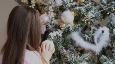 Evde Noel ağacı süsleyen sevimli küçük kız.