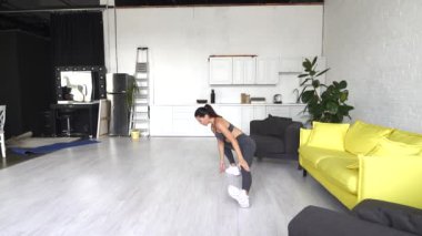 Güzel genç bir kadın odada abdominal egzersizler yapıyor. Fitness, spor, eğitim ve insan konsepti