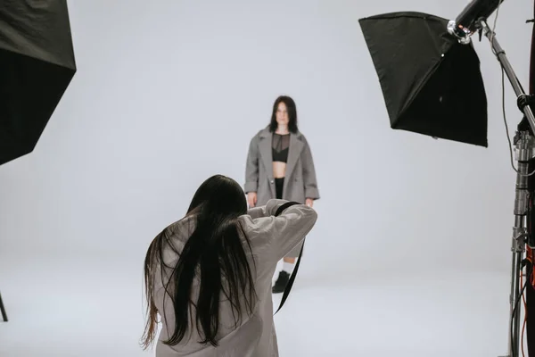写真スタジオでのファッション写真 プロの男性写真家は カメラ 舞台裏で美しい女性モデルの写真を撮る — ストック写真