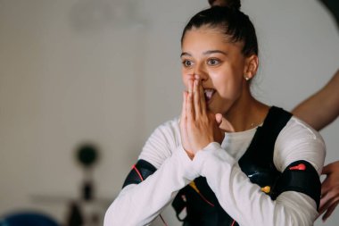 Kablolu takım elbiseyle egzersiz yapan bir kız..