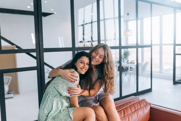 Meninas Felizes Abraçando Casa Sentado Sofá Sala Estar Casa — Fotografia de Stock
