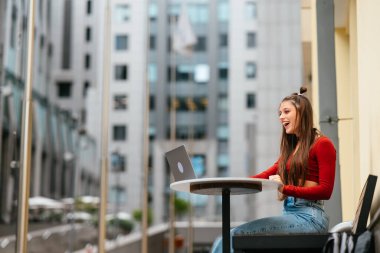 Kız caddedeki bir video bağlantısından konuşuyor. Sokakta buluşacağız. Modern iş tipleri. Uzaktan çalış.