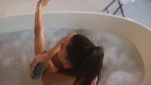 Woman Washes Her Arm Sponge While Taking Bath — Stockvideo