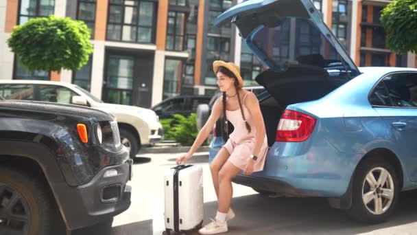 年轻快乐的女人把她的手提箱装进汽车行李箱里 假日概念 — 图库视频影像