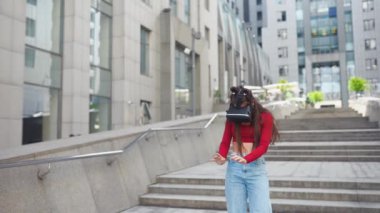 Sanal gerçeklik kasklı bir kadın sokakta yürüyor.