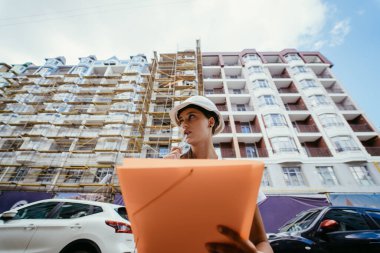 İnşaat mühendisi kadın inşaat alanında güvenlik önlüğü takıyor. Kadın inşaat mühendisi konsepti