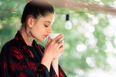 Çay fincanından içen bir kadın resmi, yakın görüş.