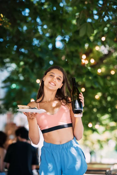 Young Woman Carries Plate Snacks One Hand Drink Other — Foto Stock