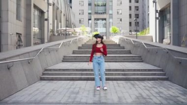 Sanal gerçeklik kasklı bir kadın sokakta yürüyor.