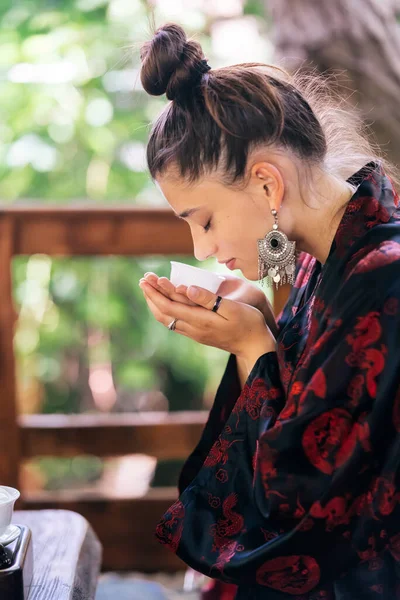 Process brewing tea. Young woman enjoys the smell of green tea