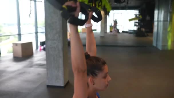 경기에서 여자가 헬스클럽에서 끈으로 운동을 — 비디오