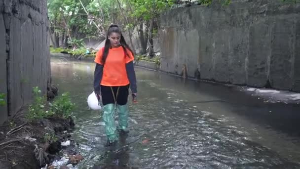 雨のコレクターに沿って若い女性の掘削機が歩く — ストック動画