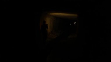 Elinde fener olan genç bir kadın kazıcı tüneli keşfediyor.