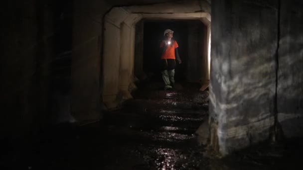 Young Female Digger Flashlight Explores Tunnel — Stock Video