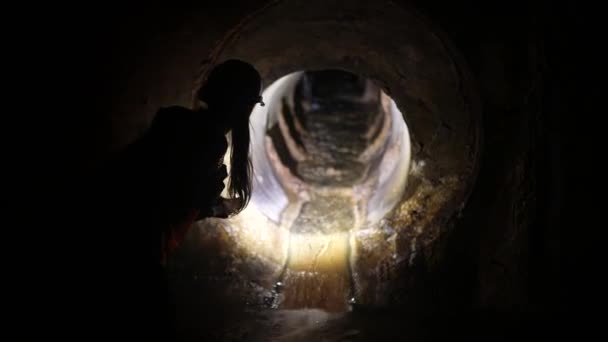 Young Female Digger Flashlight Explores Tunnel — Stock Video