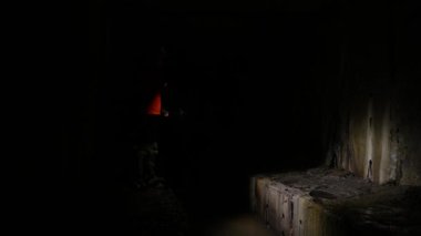 Elinde fener olan genç bir kadın kazıcı tüneli keşfediyor.