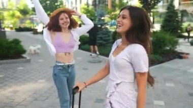 Dostça bir konuşma. Konuşan ve dışarıda duran iki güzel genç kadının yan görüntüsü.