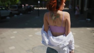 Neşeli stil sahibi, sıradan bir öğrenci kadın şehirde dolaşırken siyah kablosuz kulaklıklar kullanarak müzik dinlemekten hoşlanıyor..