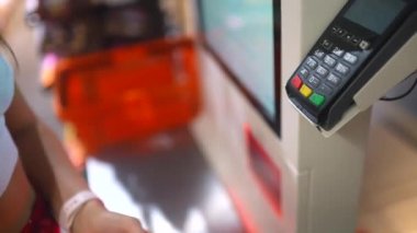 Yapay uzuv tarama ürünleri olan kadın müşteri marketteki self-servis kasasında..