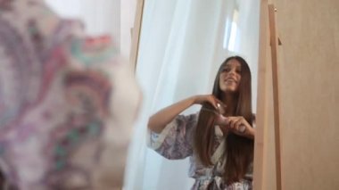 Aynanın önünde saçını tarayan bir kadın..