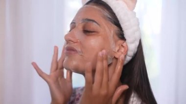 Yüzüne maske takan güzel bir kadın. Cilt bakımı ve tedavisi, spa, doğal güzellik ve kozmetoloji konsepti