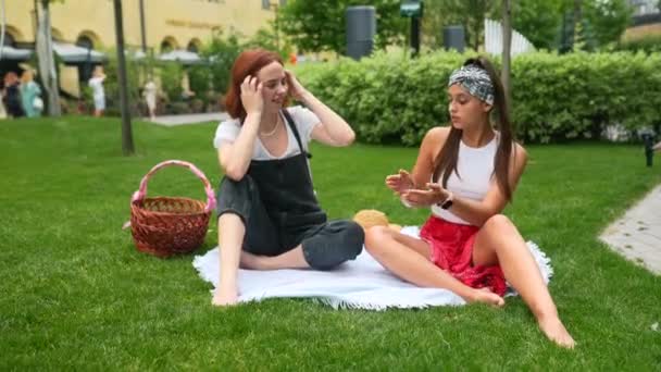 Two Women Having Picnic Together Laying Plaid Lawn — Stockvideo