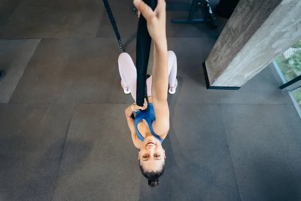 Young woman is climbing a rope in the gym Concept of sport.