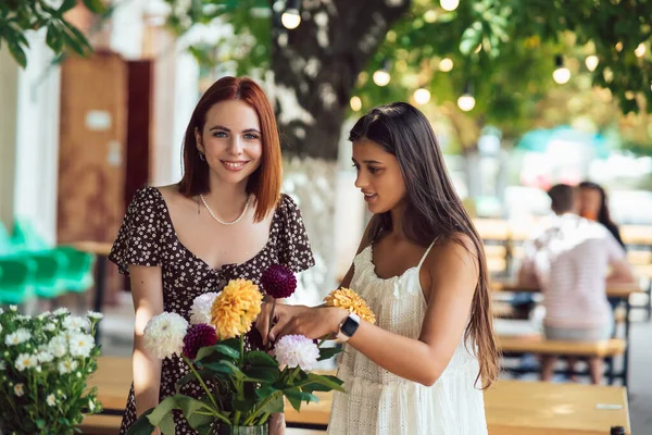 งสาวสองคนร งและท อดอกไม สวยงาม ดอกไม และช อดอกไม านกาแฟข างถนน จขนาดเล — ภาพถ่ายสต็อก