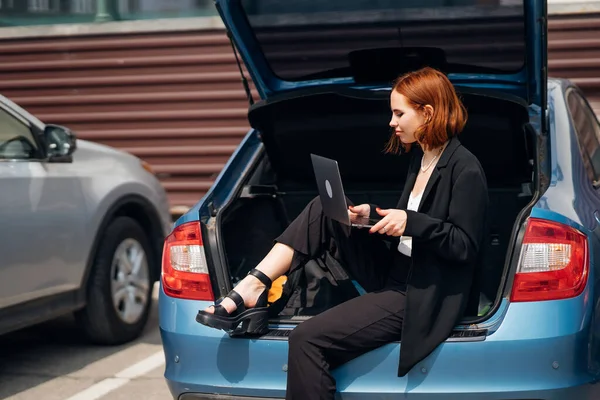 Çekici Genç Kadın Seyahat Ederken Arabanın Bagajında Otururken Dizüstü Bilgisayarda — Stok fotoğraf