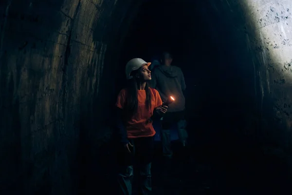 Young Female Digger Flashlight Explores Tunnel — Stock Photo, Image