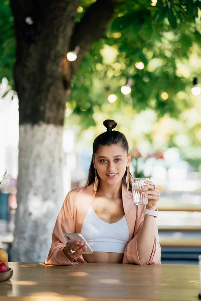 Woman with a cold drink sitting in a cafe on the street