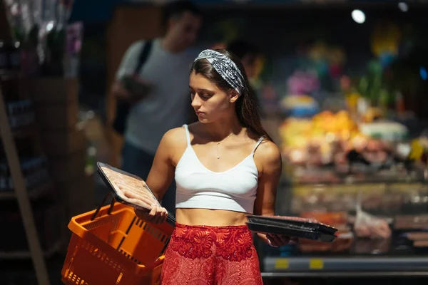 Young woman shopping for meat in a grocery store