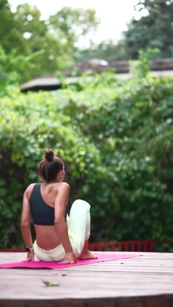 Genç Bir Kadın Sabah Tahta Bir Podyumda Yoga Yapıyor — Stok video