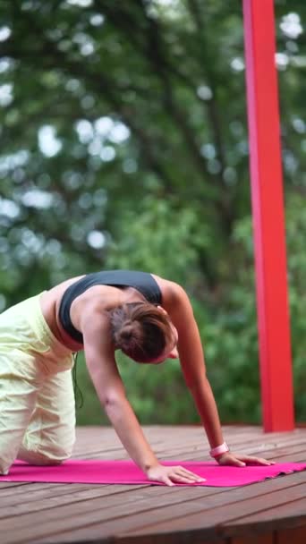 Junge Frau Praktiziert Morgens Yoga Auf Einem Holzpodest — Stockvideo