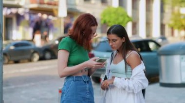 İki turist arkadaş akıllı bir telefondan online rehbere başvuruyor.