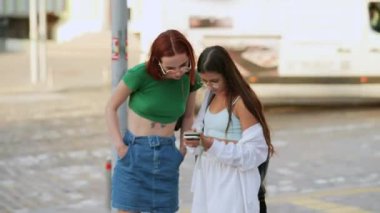 İki turist arkadaş akıllı bir telefondan online rehbere başvuruyor.