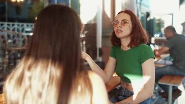 Dos Amigas Guapas Hablando Mientras Están Sentadas Bar Calle Ciudad — Vídeo de stock