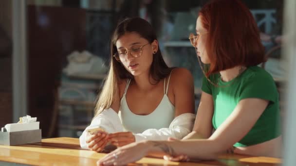 Due Giovani Ragazze Eccitate Che Usano Telefoni Cellulari Mentre Siedono — Video Stock