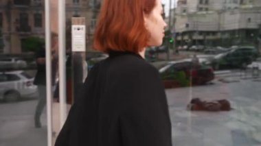 Sokakta yürüyen kendine güvenen ve şık giyimli bir iş kadını. Başarılı olma arzusuyla hareket eden.