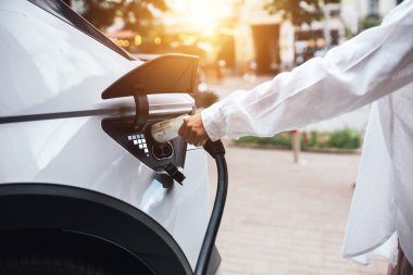 insan eli meme şarj elektrikli araba tutuyor. seçici odak el ve meme