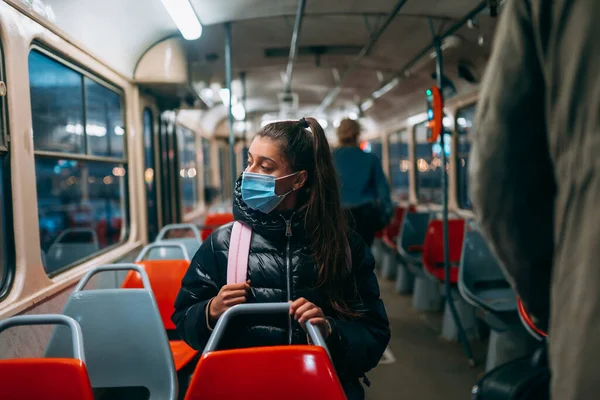 Young woman with mask traveling in the public transport by bus. Unique protective mask of the respiratory tract from coronavirus.