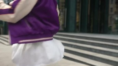 Çok güzel, sıska, mini etekli, sokakta dönen genç bir kız.