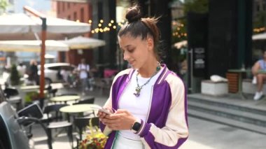 Yürüyüş ve sokağın ortasında bir akıllı telefon kullanan kadın
