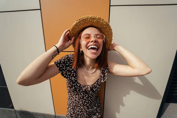 Cute young woman with a lovely sense of humour in an urban street laughing at the camera