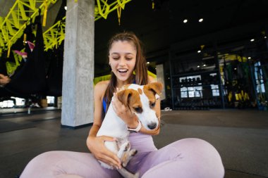 Beden eğitiminde, sahibi olan kadınla birlikte küçük sevimli Jack Russell köpeği. Sağlıklı bir yaşam tarzı.