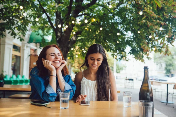 Две Подруги Просматривают Мобильные Телефоны Сидя Вместе Городском Кафе — стоковое фото