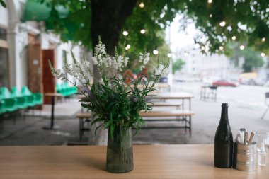 Kafenin yanındaki tahta masa ve sandalyeler..