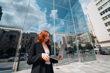 Gülümseyen kadın dışarıda dizüstü bilgisayarına bakıyor, modern yaşam tarzı, bağlantı, iş, kahve molası, iletişim, web sohbeti, sosyal medya, video konferans konsepti.