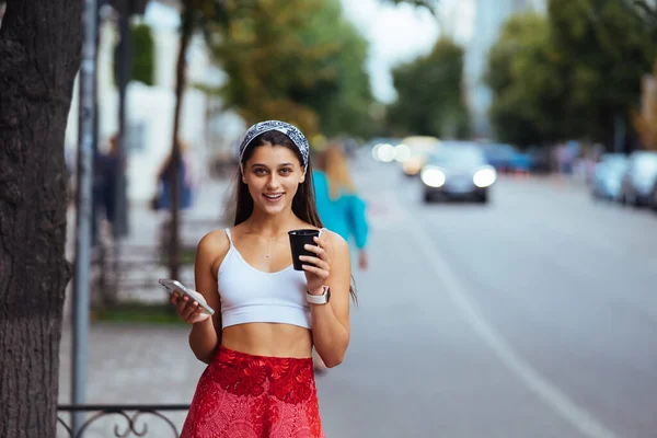 Sokakta Sabah Kahvesini Içip Akıllı Telefonunu Kullanan Neşeli Bir Kadın — Stok fotoğraf