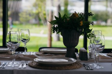 Düğün partisindeki şenlik masası limon aranjmanıyla süslenmiştir. Masanın üstünde peçete ve gözlüklerle dolu tabaklar vardır.